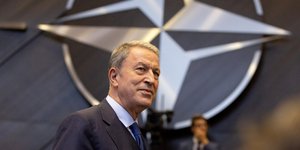 Ο Τούρκος υπουργός Άμυνας Χουλουσί Ακάρ με φόντο το σήμα της νατοϊκής συμμαχίας