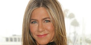 Η Τζένιφερ Ανιστον με μαύρο φόρεμα χαμογελά στον φακό 