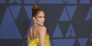 Τζένιφερ Λόπεζ με χρυσό φόρεμα και μαύρο τσαντάκι