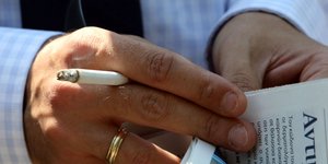 Χέρι αντρικό με τσιγάρο και εφημερίδα
