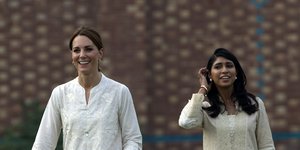 Η Κέιτ Μίντλετον με λευκά περπατάει και χαμογελάει