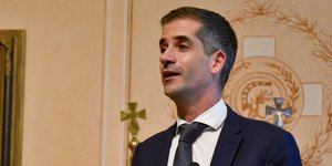 Ο Δήμαρχος Αθηναίων Κώστας Μπακογιάννης σε ομιλία με μπλε σακάκι και γκρι γραβάτα