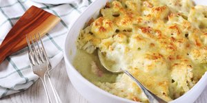 Πυρίμαχο με κουνουπίδι ογκρατέν στο τραπέζι πλάι σε κουτάλα και πιρούνι