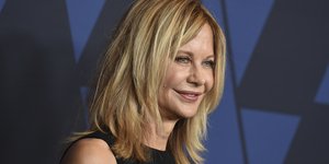 Η Μεγκ Ράιαν με μαύρο φόρεμα χαμογελάει στον φακό 