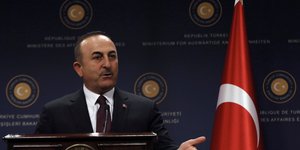 Ο Μελβούτ Τσαβούσογλου μιλά δίπλα σε Τουρκική σημαία