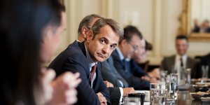 Ο Κυριάκος Μητσοτάκης παρακολουθεί συνομιλητή στο υπουργικό συμβούλιο