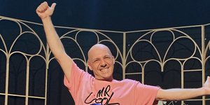 Ο Νίκος Μουτσινάς με τα χέρια ψηλά στη θεατρική σκηνή