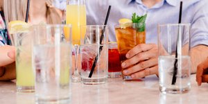 Ανδρας και γυναίκα κάθονται σε τραπέζι και έχουν μπροστά τους πολλά ποτήρια γεμάτα νερό και ροφήματα
