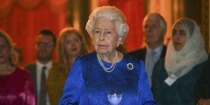 Η βασίλισσα Ελισάβετ με μπλε φόρεμα κρατά ποτήρι