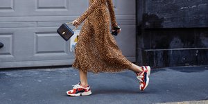 γυναίκα περπατά με sneakers και τσάντα
