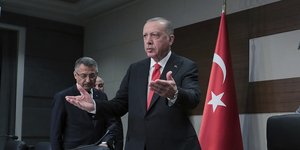 Ο Ρετζέπ Ταγίπ Ερντογάν όρθιος με σηκωμένα χέρια