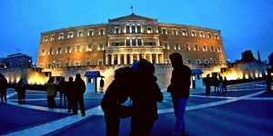 Κόσμος μπροστά από τη φωτισμένη Βουλή το σούρουπο