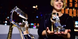 γυναικα κραταει χρυσά παπούτσια 