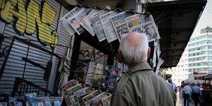 Ανδρας διαβάζει εφημερίδες σε κιόσκι