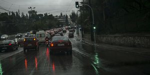 Αυτοκίνητα στον δρόμο, ενώ βρέχει