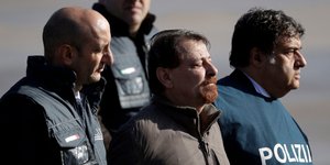 Ο Τσέζαρε Μπατίστι ανάμεσα από αστυνομικούς