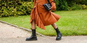 γυναίκα περπατά με φούστα και μπότες στην εβδομάδα μόδας