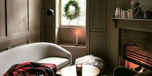 Kαθιστικό με λευκό καναπέ, τραπεζάκι, στεφάνι, τζάκι