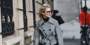 γυναίκα περπατά στην εβδομάδα μόδας με πανωφόρι και τοπ