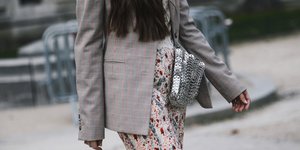 γυναίκα περπατά με φούστα και τσάντα στην εβδομάδα μόδας