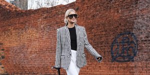 γυναίκα περπατά με γυαλιά και σακάκι στην εβδομάδα μόδας