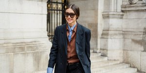 γυναίκα περπατά με κοστούμι και πουκάμισο στην εβδομάδα μόδας