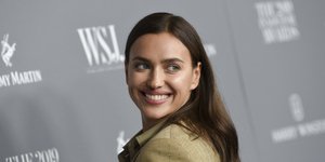 H Ιρίνα Σάικ με μπεζ κοστούμι χαμογελάει στον φακό 