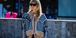 γυναίκα περπατά με αθλητικό πανωφόρι στην εβδομάδα μόδας