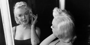 Η Μέριλιν Μονρόε με λαμπερό δέρμα κοιτάζεται στον καθρέφτη