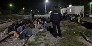 Μετανάστες φρουρούνται από αστυνομικό σε γραμμές τρένου στη Κροατία