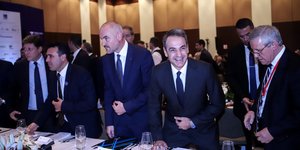 Ο Κυριάκος Μητσοτάκης κάθεται χαμογελαστός σε τραπέζι μαζί με ηγέτες χωρών