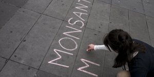 Διαδηλώτρια γράφει το όνομα της Monsanto στο πεζοδρόμιο σε διαμαρτυρία σε βάρος της εταιρίας στο Σαν Φρανσίσκο
