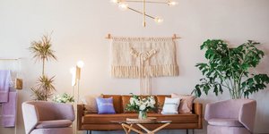 Καναπές, δύο μωβ πολυθρόνες, φυτά, τραπεζάκι