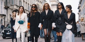 γυναίκες περπατούν στην εβδομάδα μόδας με μπότες και γυαλιά