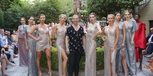 Ο Βασίλειος Κωστέτσος με σανδάλια ποζάρει μαζί με τα μοντέλα του σε επίδειξη μόδας του