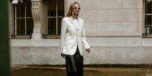 γυναίκα περπατά στο δρόμο με σακάκι και γυαλιά