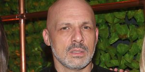 Ο Νίκος Μουτσινάς με μαύρο πουκάμισο