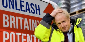 Ο Μπόρις Τζόνσον με κίτρινο γιλέκο κρατά το κεφάλι του