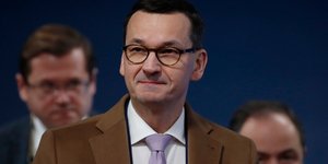 O Ματέους Μοραβιέτσκι με καφέ σακάκι και μοβ γραβάτα