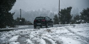 Αυτοκίνητο κινείται σε χιονισμένο δρόμο