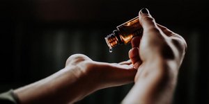 Γυναίκα κρατά μπουκαλάκι με αιθέρια έλαια