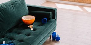 Πράσινος βελούδινος καναπές με μπολ πατατάκια 