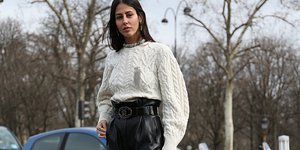 γυναίκα με δερμάτινο παντελόνι και πουλόβερ στην εβδομάδα μόδας