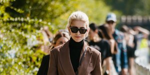 Γυναίκα περπατάει στο δρόμο ντυμένη στα καφέ και φοράει μπότες