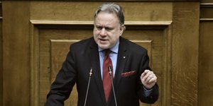 Ο Γιώργος Κατρούγκαλος στο βήμα της Βουλής με κόκκινη γραβάτα