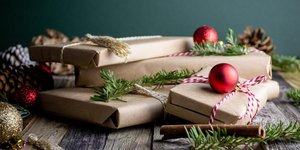 Γιορτινά δώρα με χάρτινο περιτύλιγμα, ξύλα κανέλας, κόκκινες μπάλες