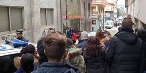 Κρατούμενοι οδηγούνται σε περιπολικό μπροστά σε κόσμο στα Γρεβενά
