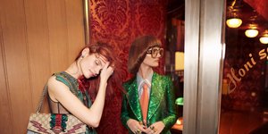 μοντέλα με φόρεμα και κοστούμι σε εστιατόριο στην καμπάνια του Gucci