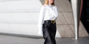 Γυναίκα με λευκό πουκάμισο και μαύρη δερμάτινη φούστα 