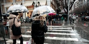 Γυναίκες με ομπρέλες σε δρόμο της Θεσσαλονίκης